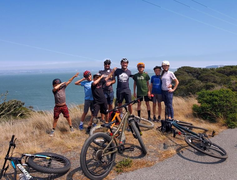 Brian mountain biking with his kids and friends above the bay